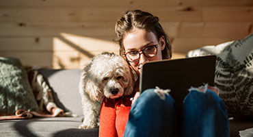 Woman with dog sitting on couch