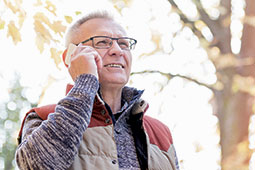 Older man talking on cell phone outdoors