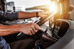 Hands on the steering wheel of commercial truck