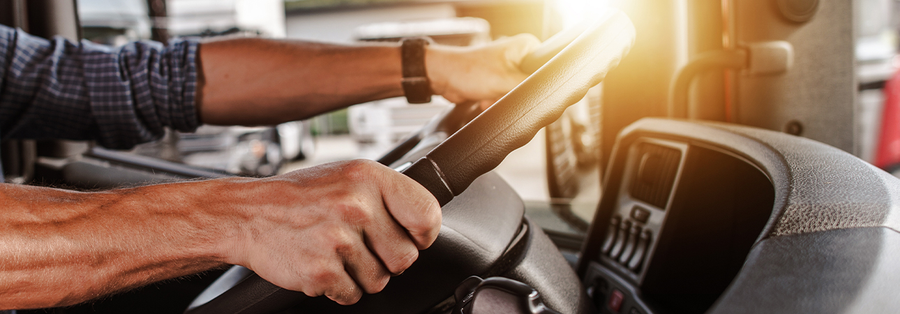 Man with hands at steering wheel